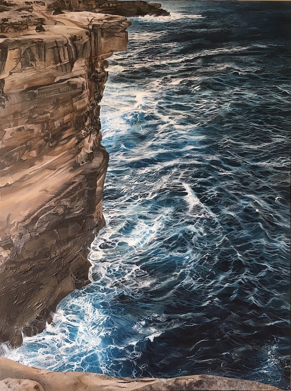 A large acrylic seascape painting of ocean waves crashing against a large rocky cliff, by fine artist Andreea Ionela Berindei