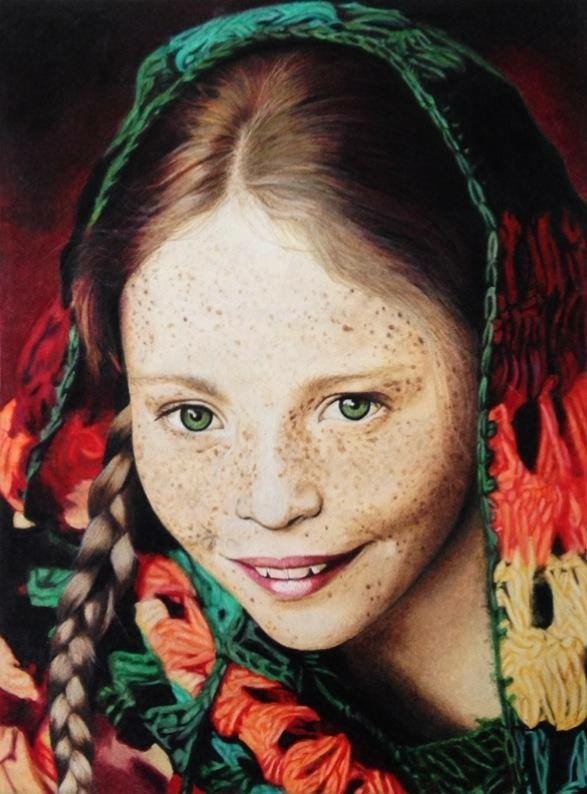 Oil based colour pencil portrait on smooth surface paper. A young girl with green eyes and blonde freckles is smiling, wearing a red, green, and yellow headscarf with a braided hairstyle. By fine artist Andreea Ionela Berindei