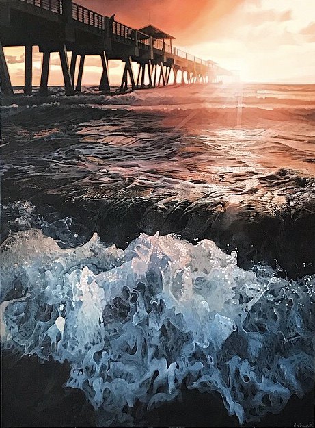 A large painting of a wooden pier in California, USA. Sunset rays over the ocean with a pier in the background and waves crashing in the foreground. By fine artist Andreea Ionela Berindei